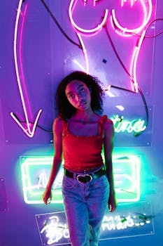 Vibrant portrait of a young adult under colorful neon lights creating an urban nightlife vibe.