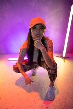 Young woman posing in vibrant neon lighting, showcasing street style and fashion.