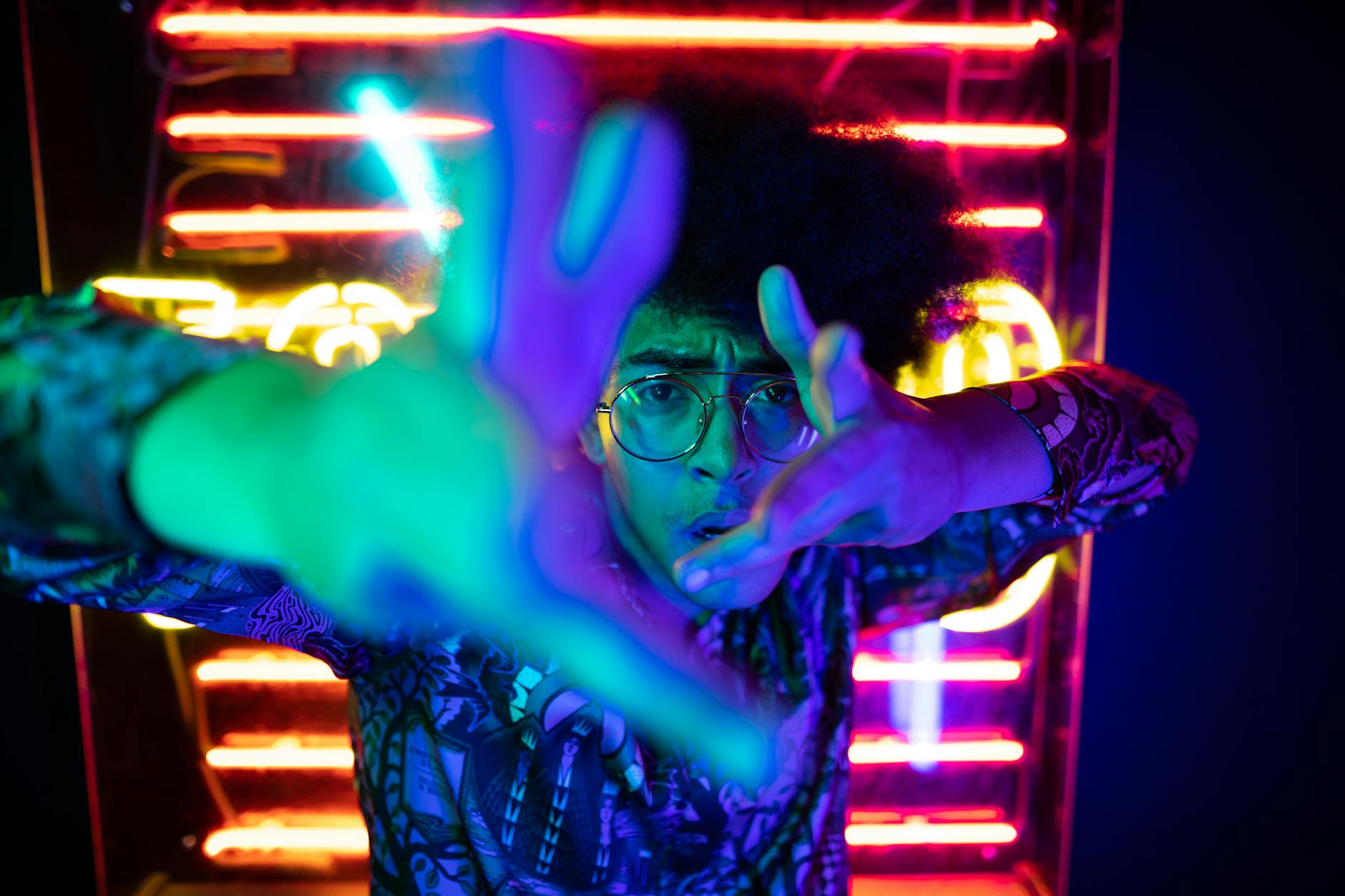 Dynamic portrait of a person surrounded by neon lights in a nightclub setting, expressing energy and style.