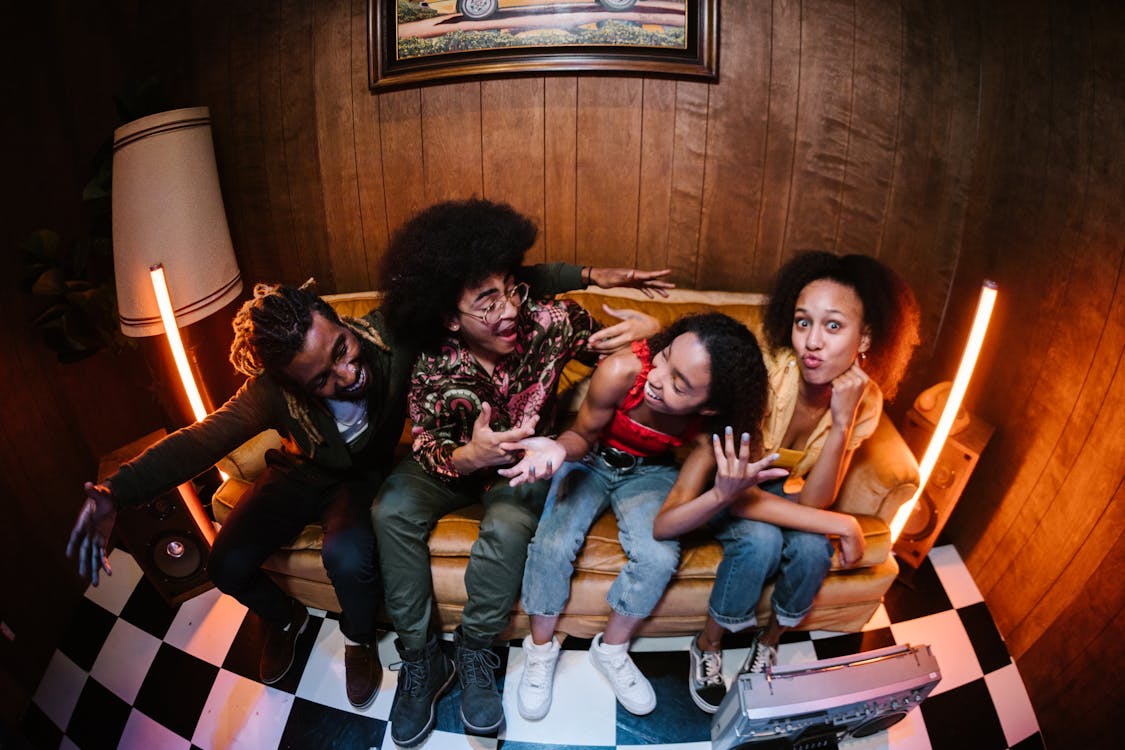 3 Women Sitting on Brown Couch