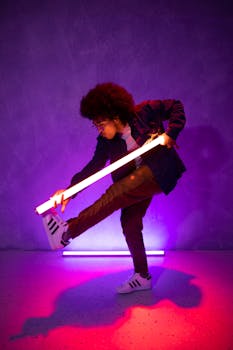 Man dancing energetically with neon lights in a vibrant nightclub setting.
