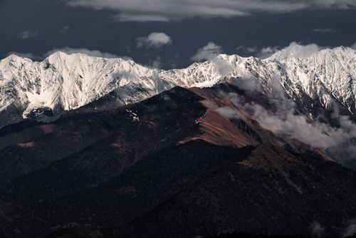Free A breathtaking view of snow-capped mountains under a dramatic sky in winter. Stock Photo