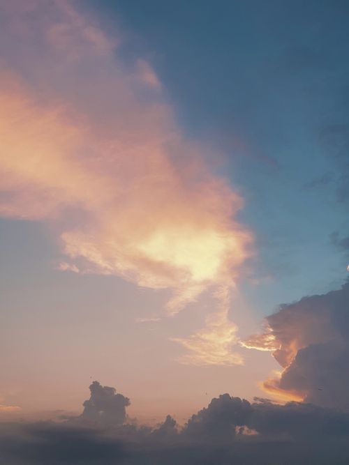 Free A tranquil sky view with vibrant colors captured at sunrise, featuring dramatic cloud formations. Stock Photo