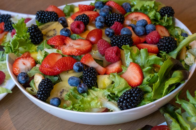 Bowl of mixed berries, kiwi and greens