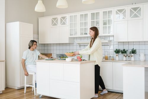 Free Interracial couple preparing a healthy meal together in a bright, modern kitchen setting. Stock Photo