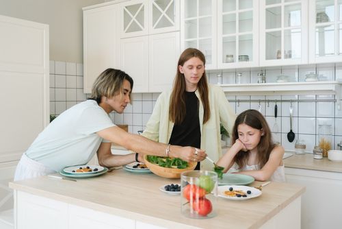 Free A diverse family enjoys meal preparation and bonding in a stylish kitchen setting. Stock Photo