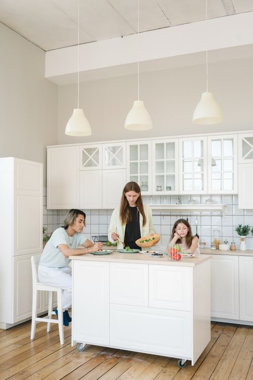 Free A family enjoys a meal together in a bright, modern kitchen, creating a warm and cozy atmosphere. Stock Photo