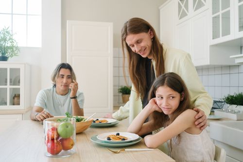 Free A family enjoys breakfast together in a bright, modern kitchen setting. Stock Photo