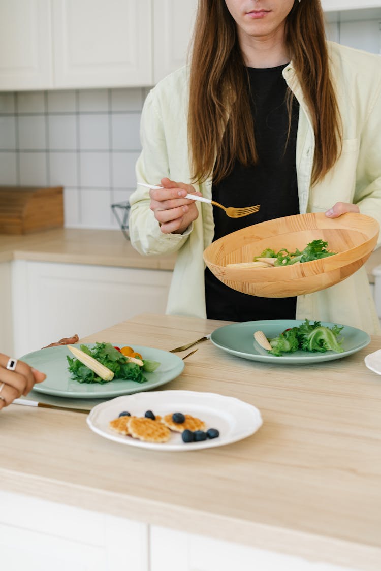 Person Holding A Wooden Bowl Of Vegetables