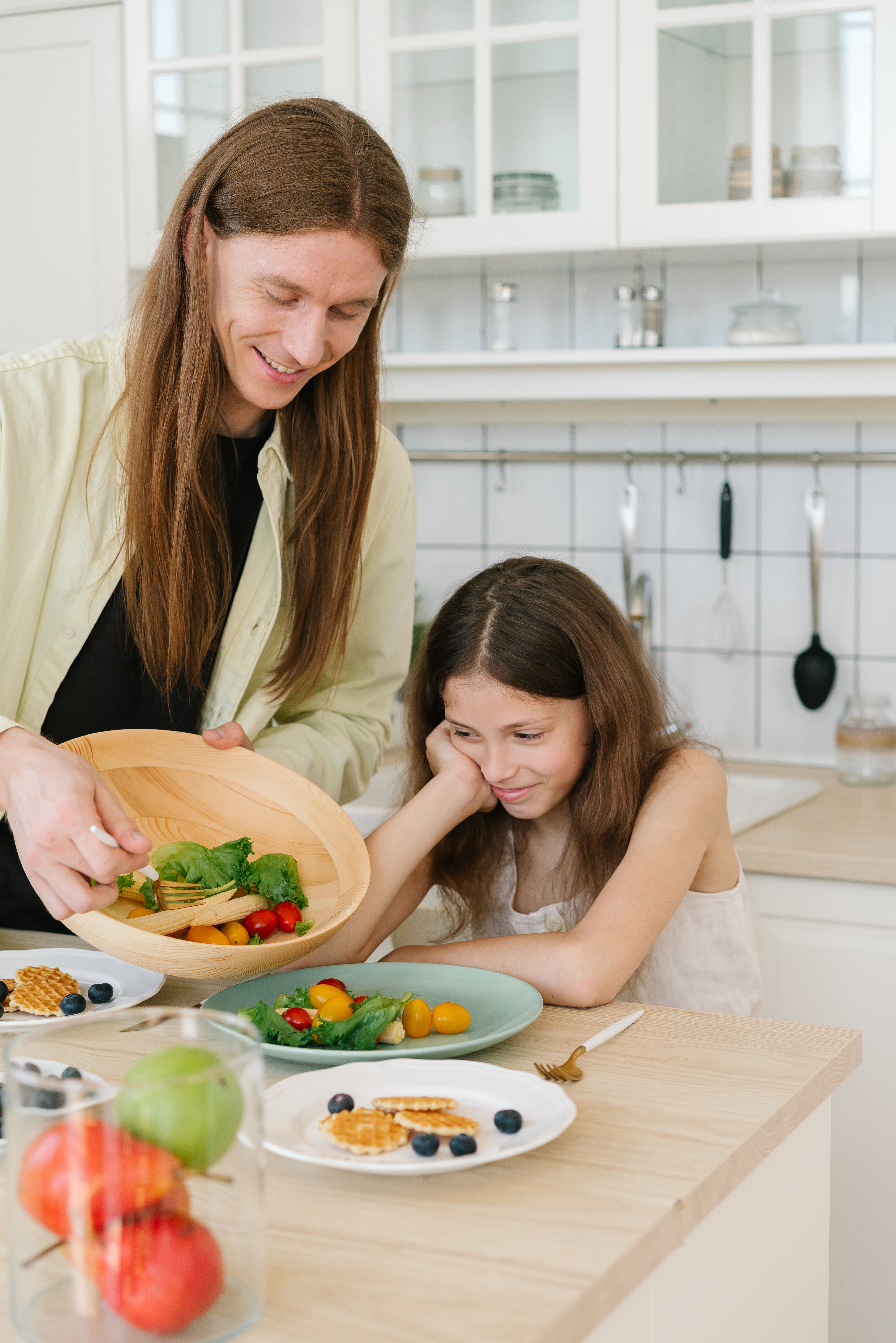 Girl with Hand on Face Sitting in a Kitchen · Free Stock Photo