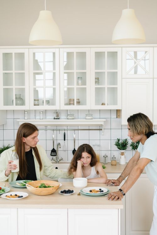 Free Family gathered in a modern kitchen having breakfast, enjoying quality time together. Stock Photo