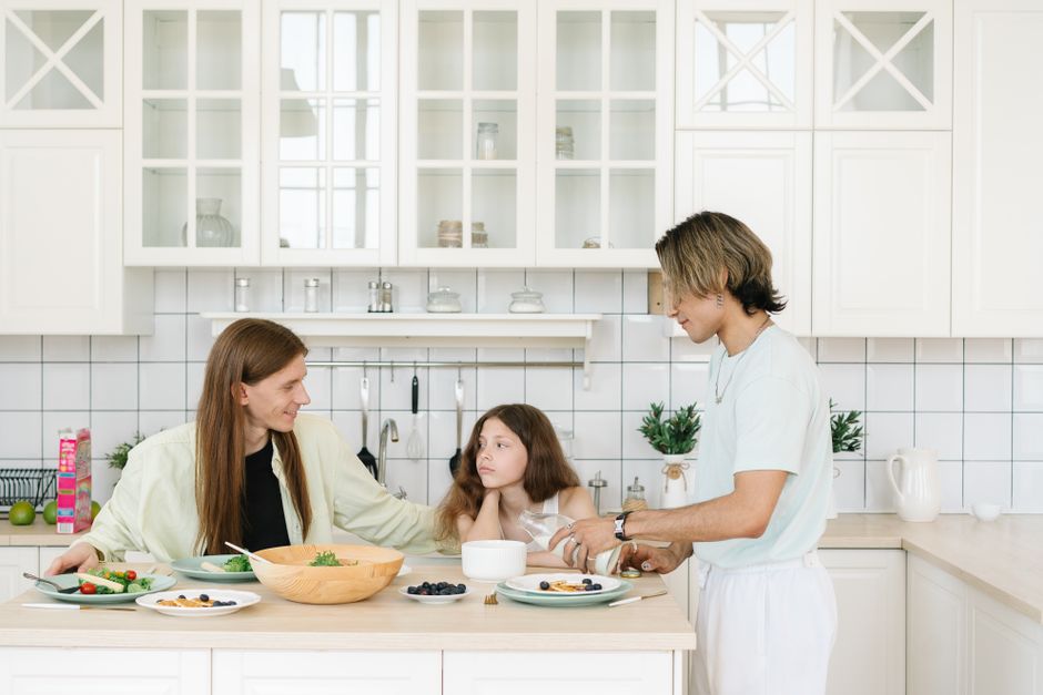 A family enjoys breakfast together in a bright, modern kitchen setting.