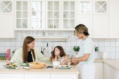 Free A family enjoys breakfast together in a bright, modern kitchen setting. Stock Photo