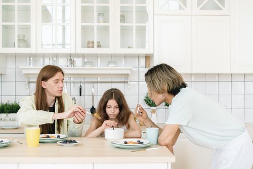 Free A family enjoys breakfast together in a bright, modern kitchen, emphasizing togetherness. Stock Photo