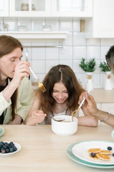A family shares a meal at a wooden table, highlighting togetherness and happiness.