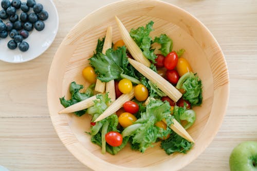 Flatlay Shot of Baby Corn and Cherry Tomatoes in Wooden Bowl
