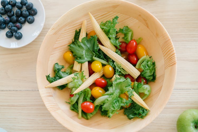 Flatlay Shot Of Baby Corn And Cherry Tomatoes In Wooden Bowl