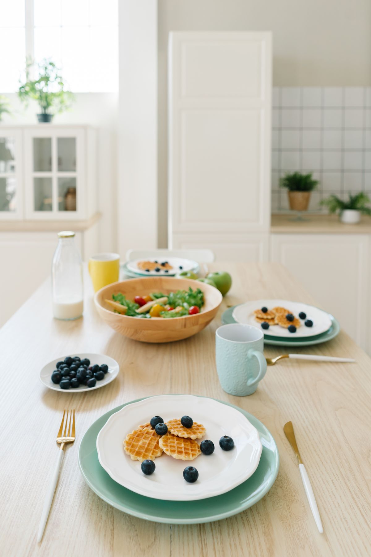 Breakfast table with waffles, fruit and other dishes