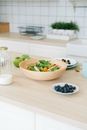 Salad on a Wooden Bowl and Blueberries on a Saucer
