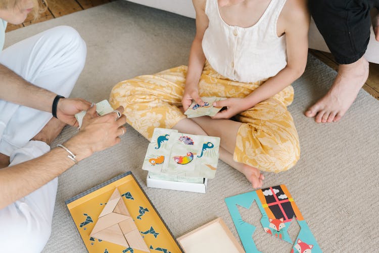 A Child Playing Puzzles While Sitting On The Carpet