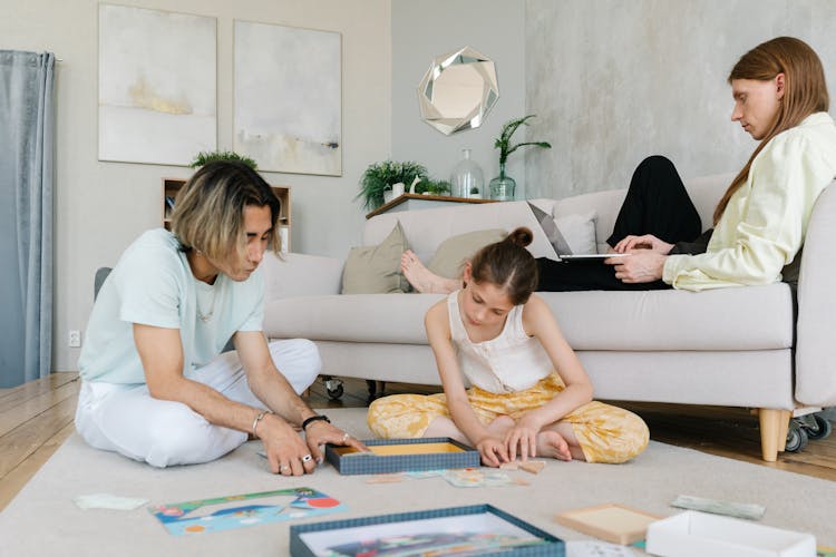 A Father Playing With His Daughter While Sitting On The Floor