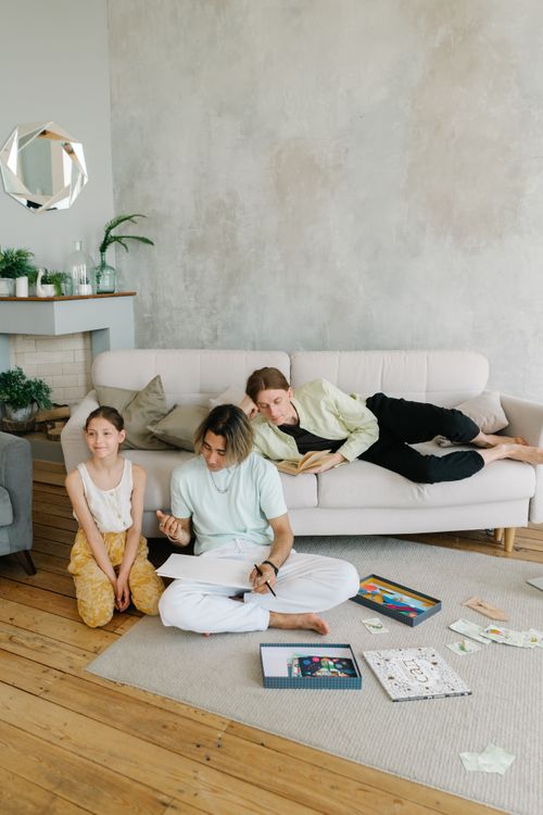 Free A family spending quality time, drawing and reading on a cozy sofa at home. Stock Photo