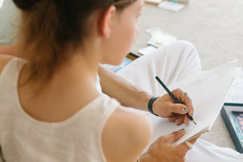 Una Persona Che Fa Il Disegno Usando Un Libro Bianco