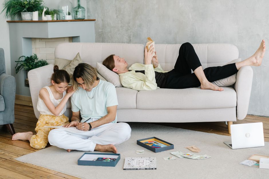 Father and daughter bonding in cozy living room with books and games, creating joyful family moments.