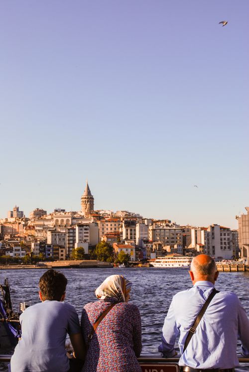 Free Panoramic view of Istanbul's skyline with Galata Tower, seen from waterfront with people in foreground. Stock Photo