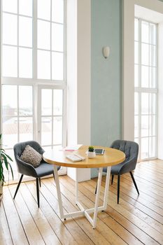 Bright office interior with round table, chairs, and large windows.