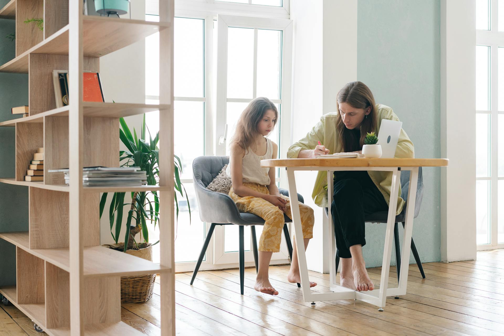 A parent tutoring their child in a cozy indoor setting, fostering learning and growth.