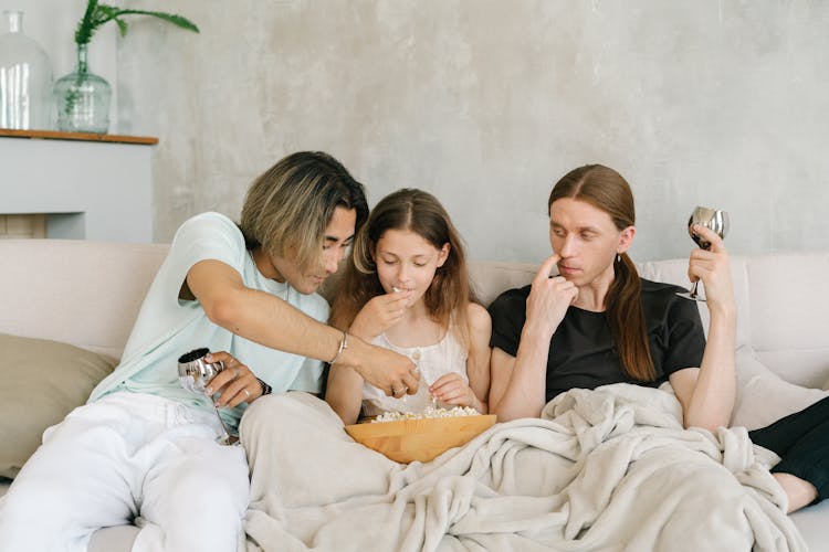 A Family Relaxing While Eating Popcorn