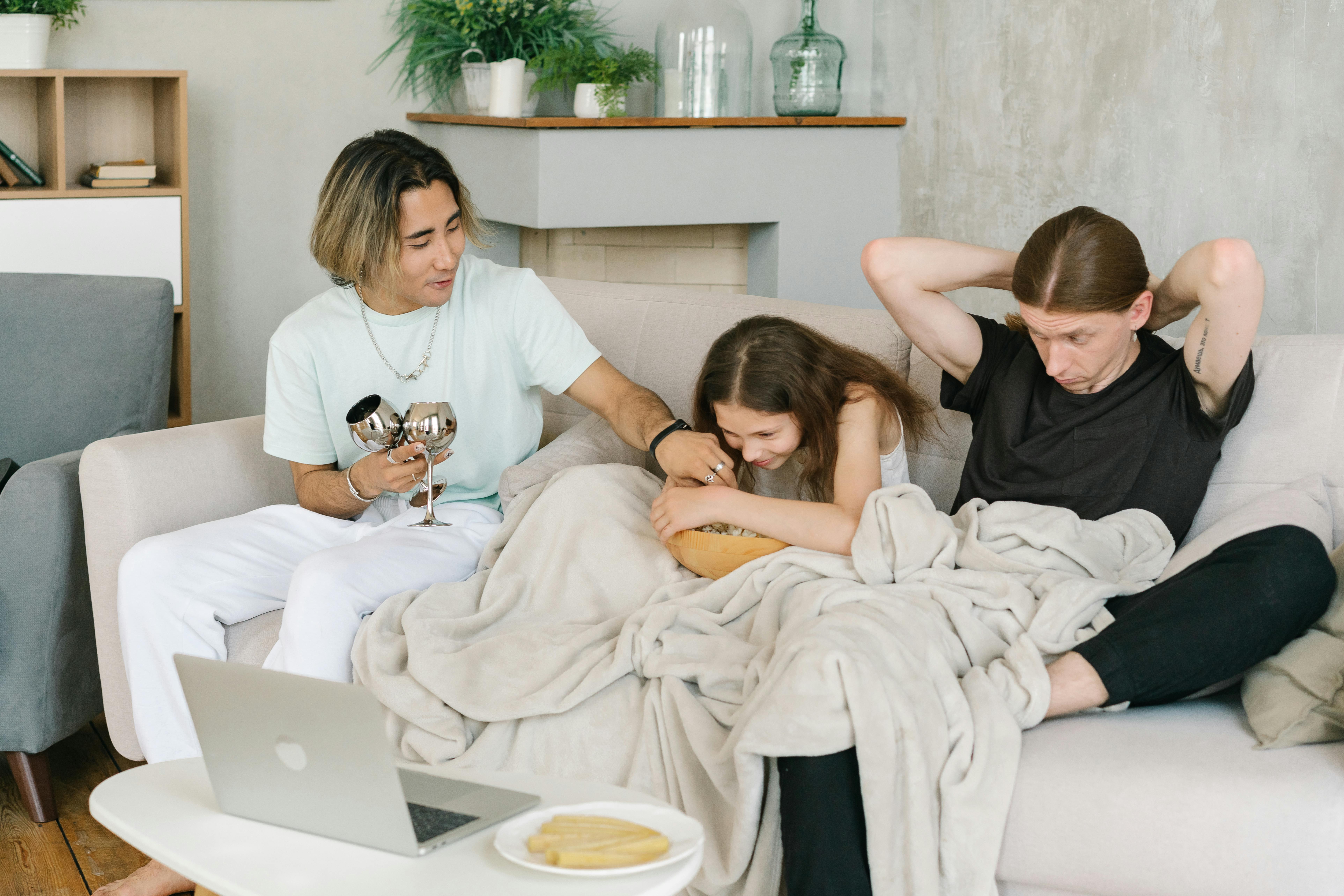 men spending time with their daughter on a couch