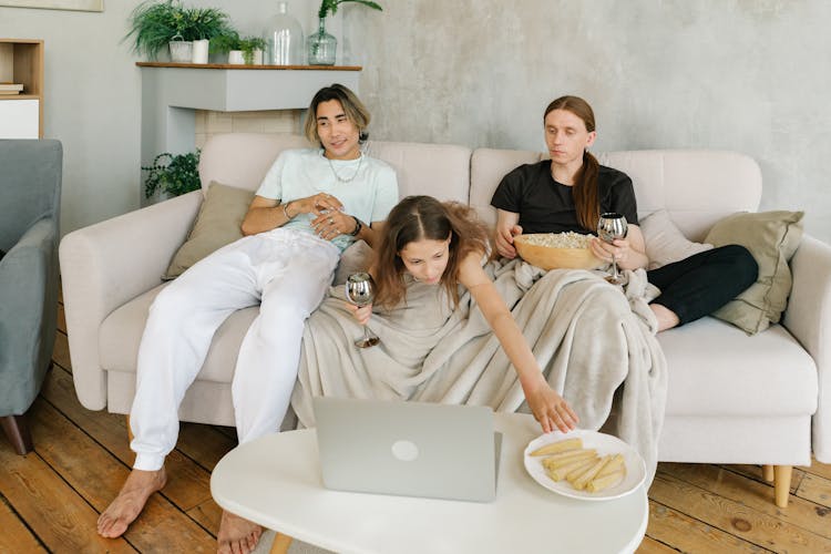 A Happy Family Sitting On The Couch While Having Conversation