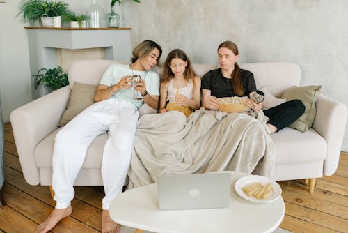 Free A Happy Family a Sitting Beside Each Other on a Couch Stock Photo
