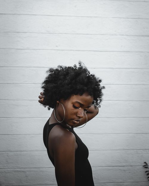 Free Stylish African woman posing outdoors against a textured wall in Nairobi, Kenya. Stock Photo