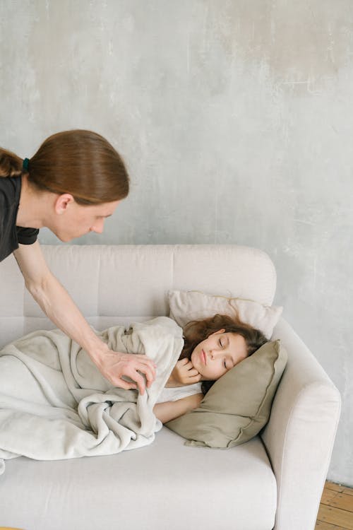 Free A Father Checking His Daughter Sleeping on the Couch Stock Photo