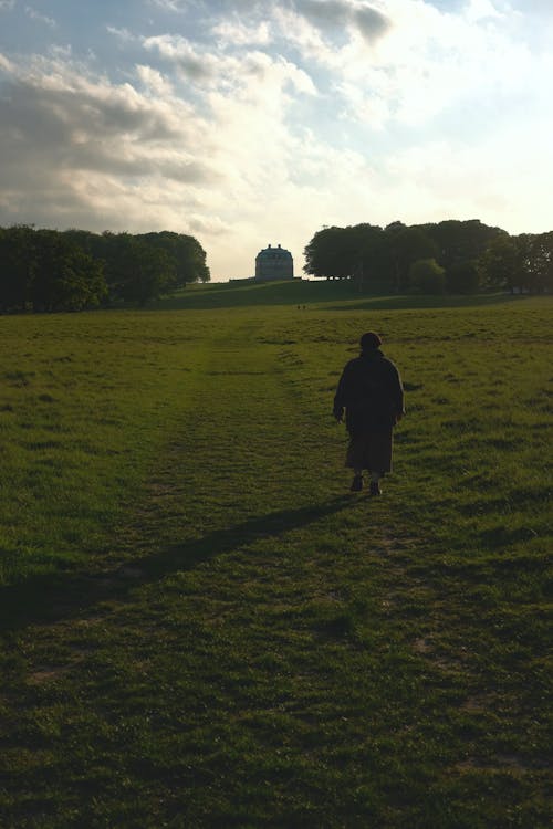 A Person Walking on a Field of Grass