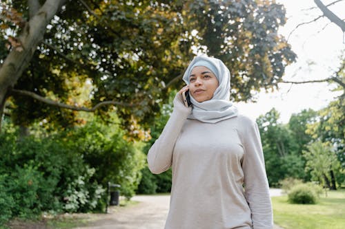 A Woman in Hijab Using a Cellphone