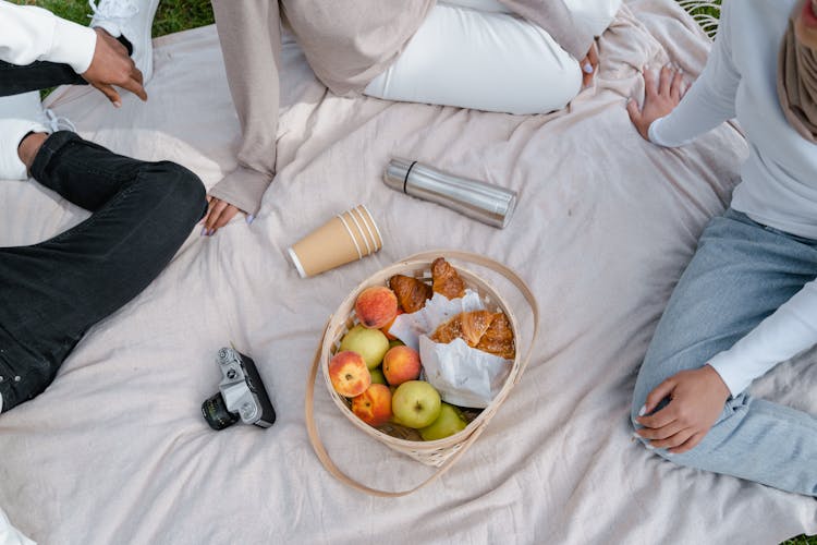 People Having A Picnic Over A Picnic Blanket