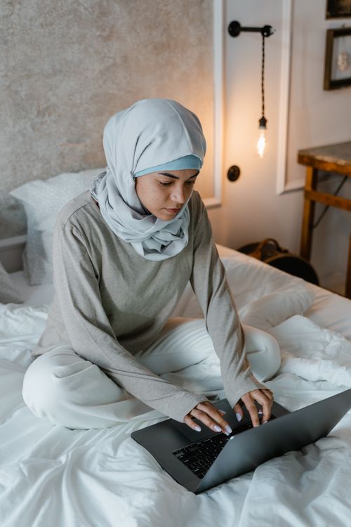 Woman in White Hijab Sitting on Bed · Free Stock Photo