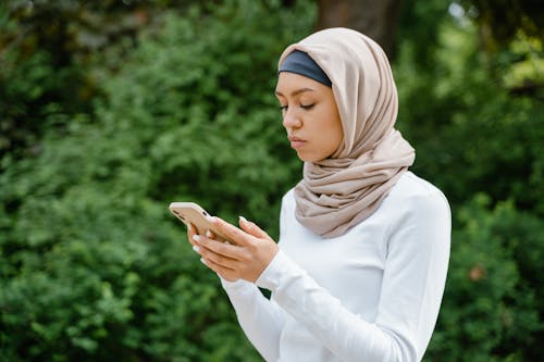Free Woman in a Hijab Texting Stock Photo