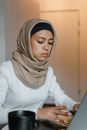 Woman in White Long Sleeve Shirt Wearing Brown Hijab