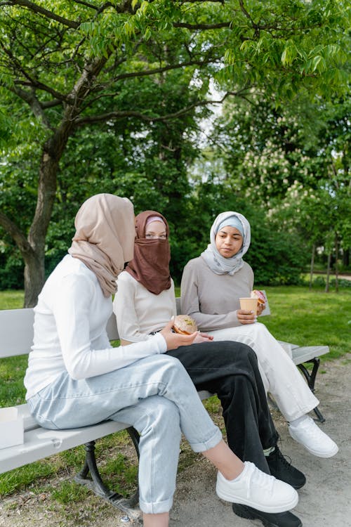 Women in Hijab Sitting Together in the Bench