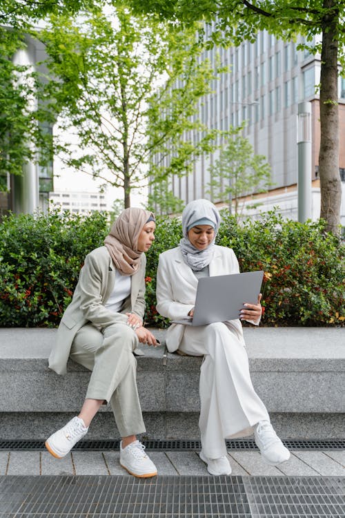 Women in Hijab Sitting near Plants and Trees