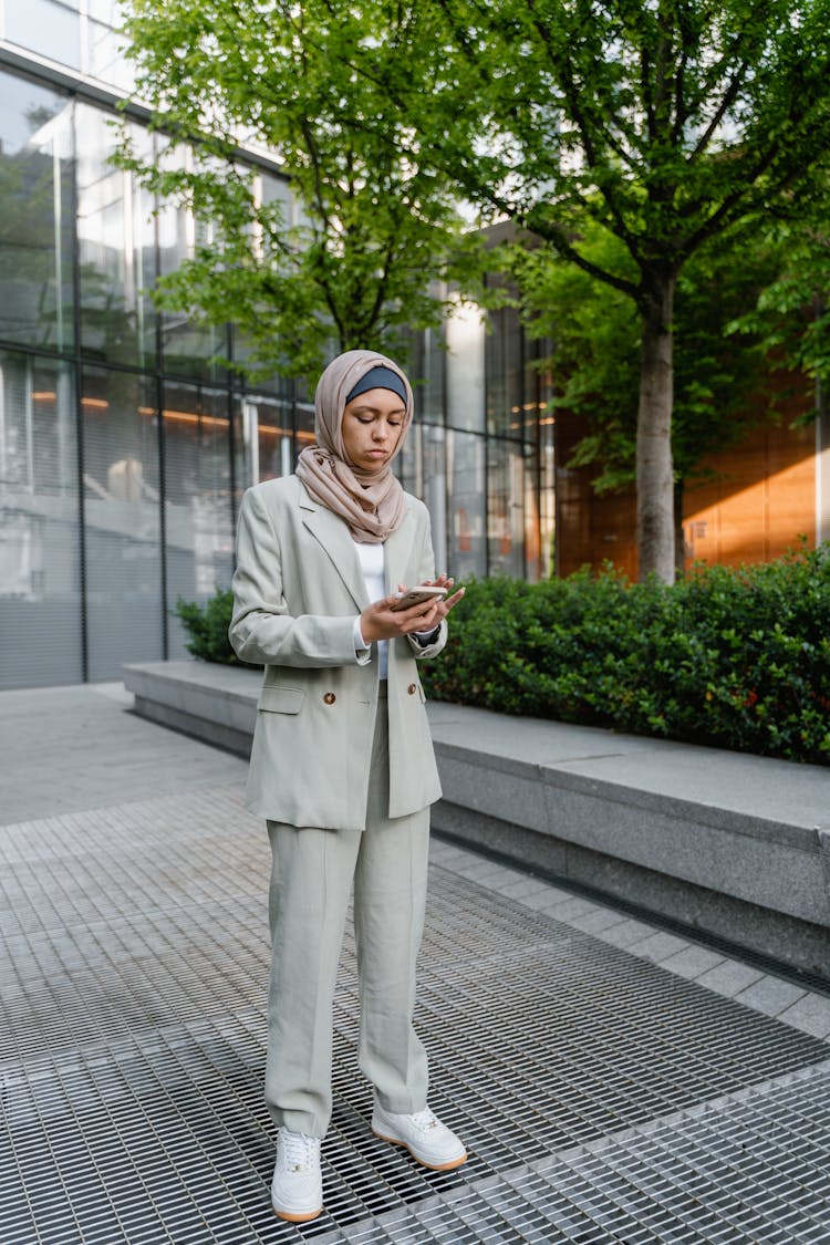 Woman Standing Outside Looking At Her Cellphone