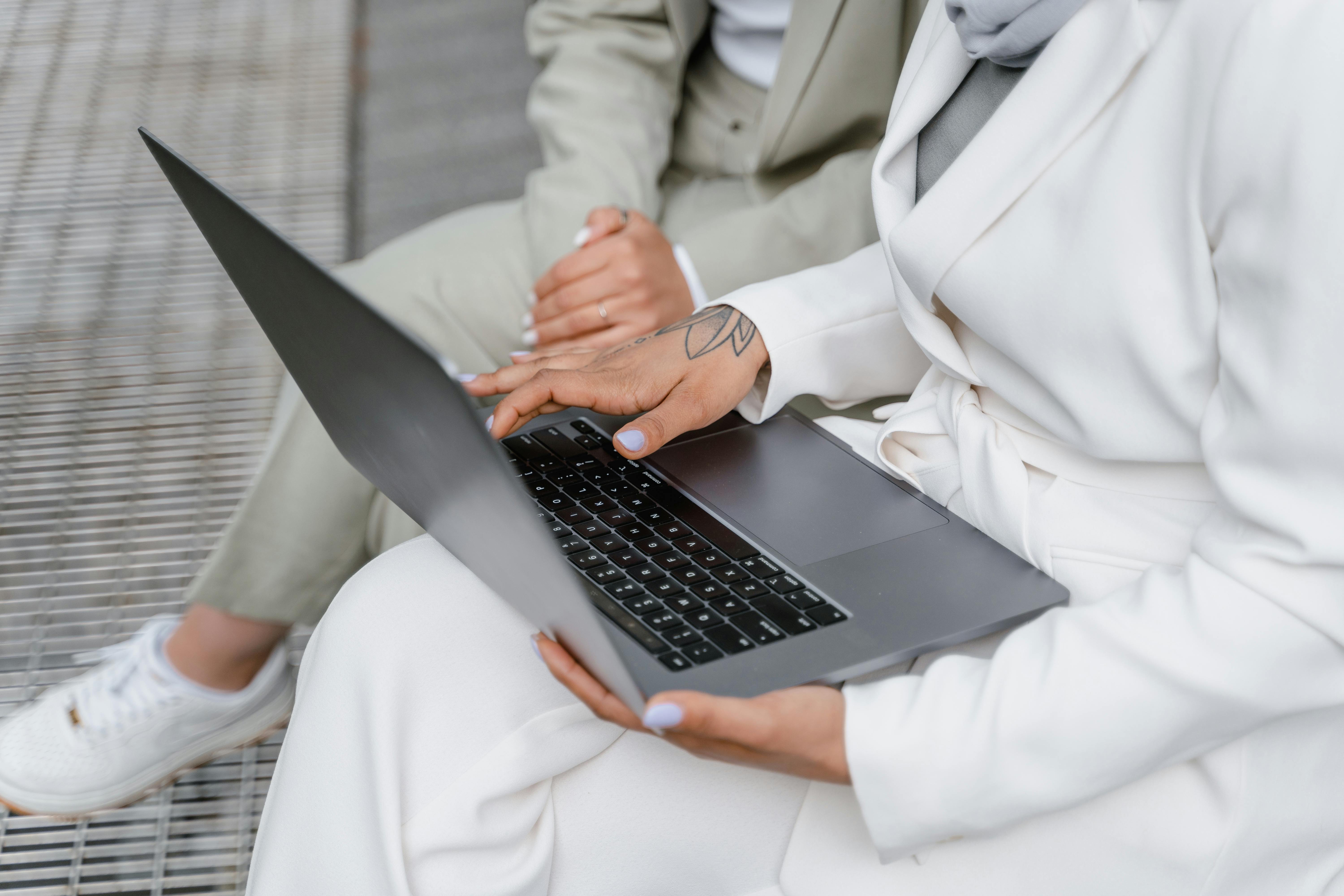 Empreendedorismo e IA: revolução na inovação digital 1 Close-up of a two professionals collaborating with a laptop, outdoors.