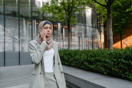 Confident woman in hijab making a call outside an office building.