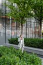 Woman in White Coat Standing Near Green Plants