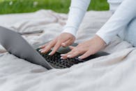 Person in White Long Sleeve Shirt Using a Laptop